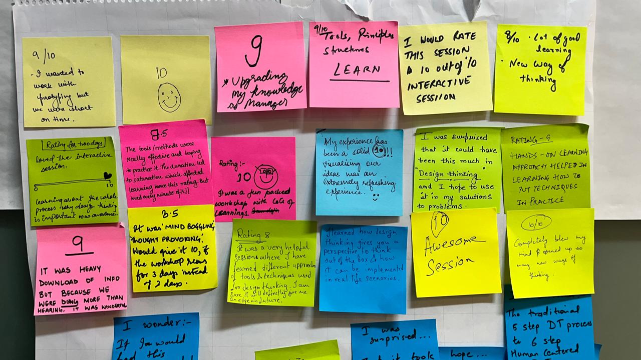 Colorful sticky notes with design thinking workshop ratings and participant reflections